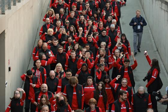 Large group of people walking. All dressed in red Canada gear.