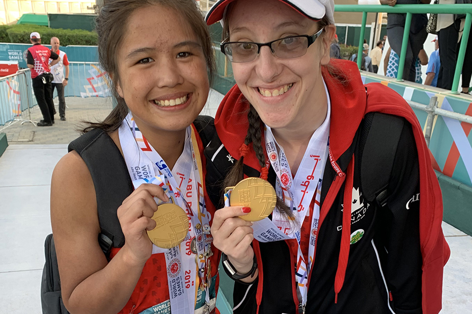 Two Special Olympics BC athletes pose for the camera with their gold medals received in track and field.