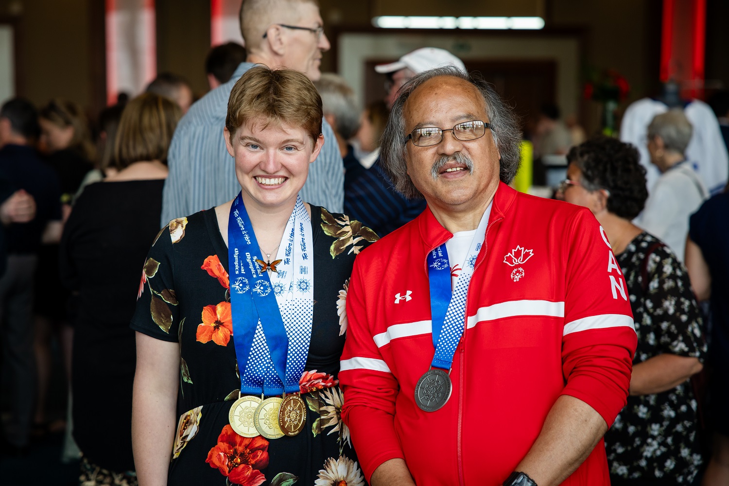 Two Special Olympics athletes standing while wearing medals at the Enriching Lives Gala Two Special Olympics athletes standing while wearing medals at the Enriching Lives Gala
