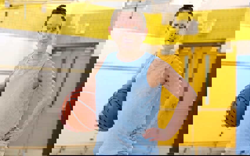 Young boy in blue tank top holding a basketball