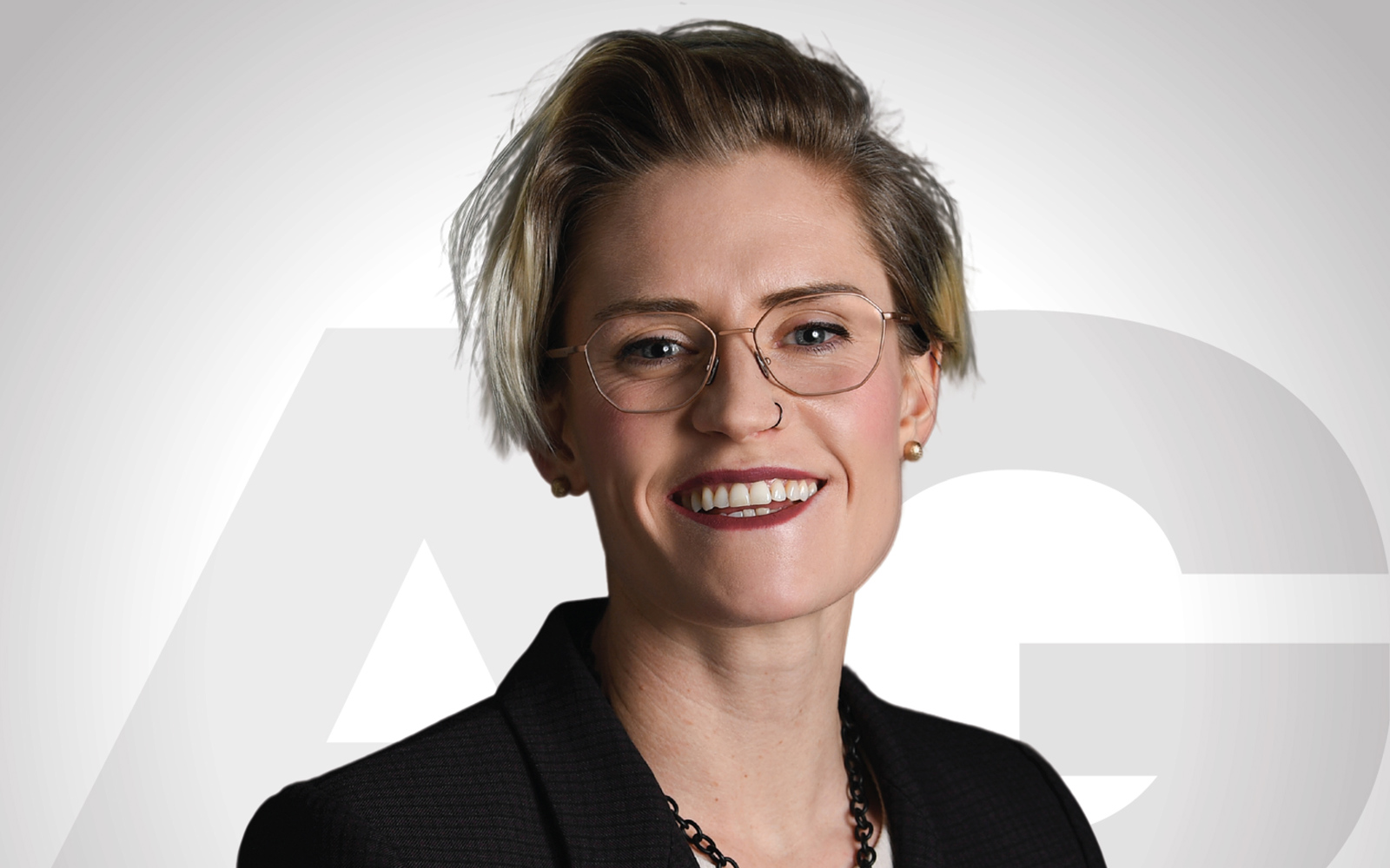Headshot of a woman with short blond hair and glasses.