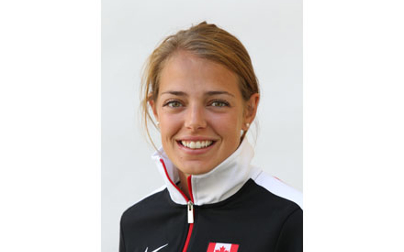 Headshot of a woman with in a Team Canada zip up jacket.