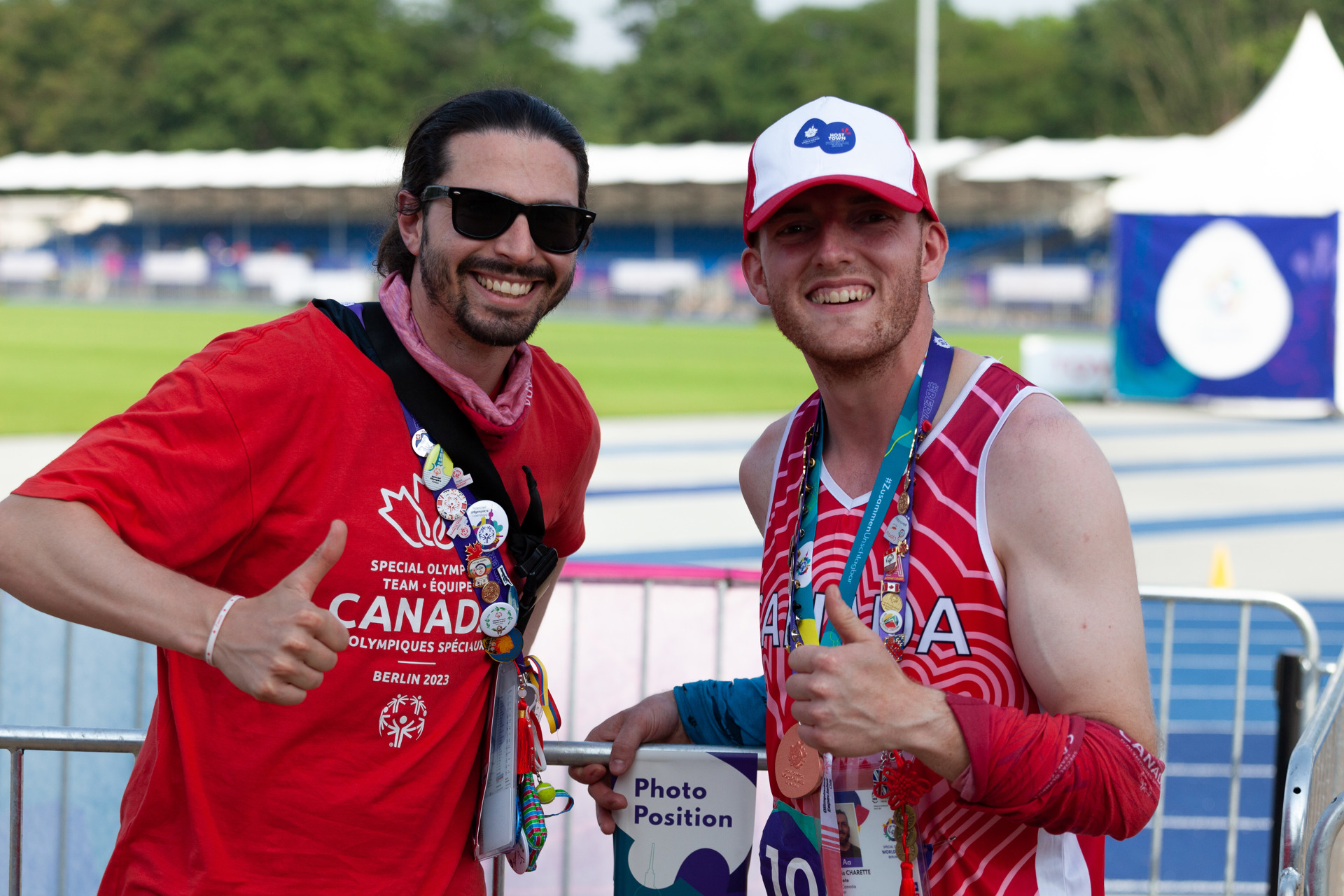 Two men smiling at the camera and giving thumbs up. 