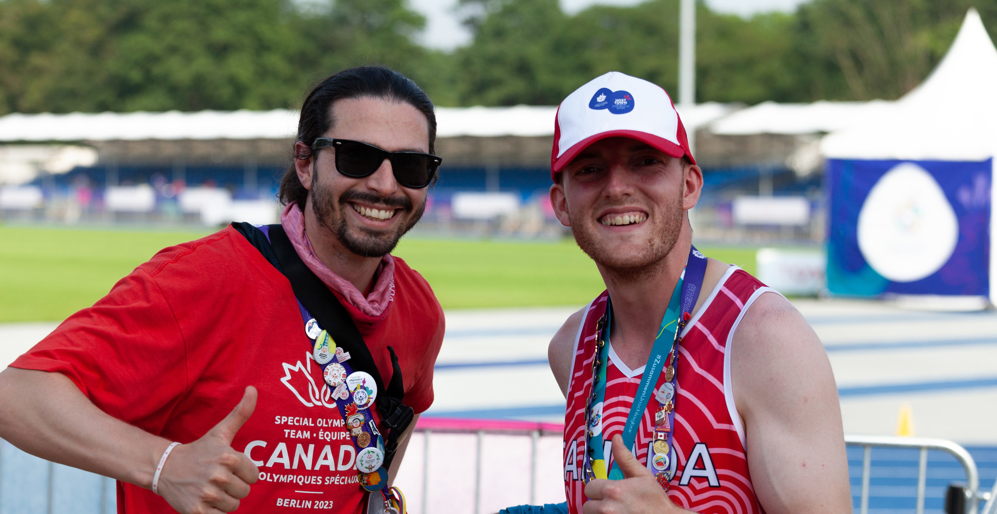 Two men smiling at the camera and giving thumbs up.
