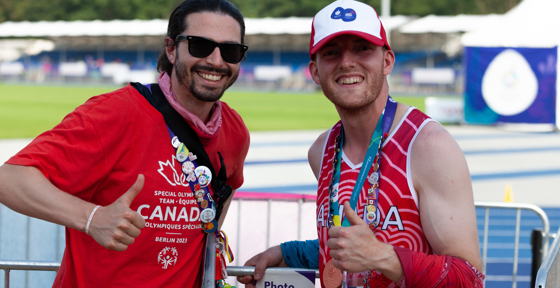 Two men smiling at the camera and giving thumbs up.
