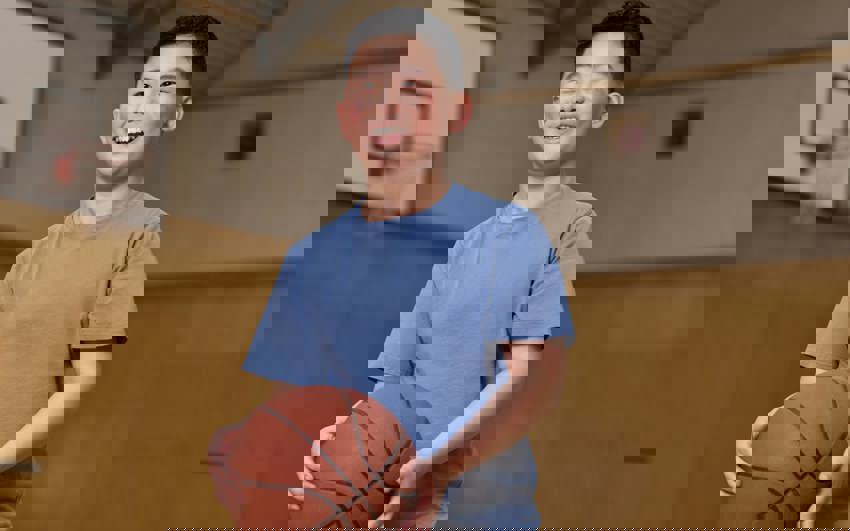 Young boy in blue shirt holding a basketball