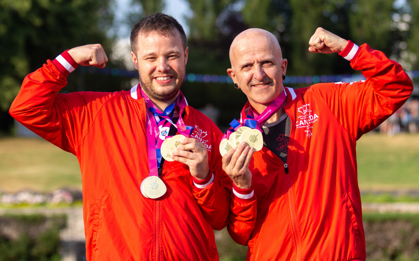 Deux athlètes vêtus de l'uniforme de l'équipe canadienne, une médaille autour du cou.