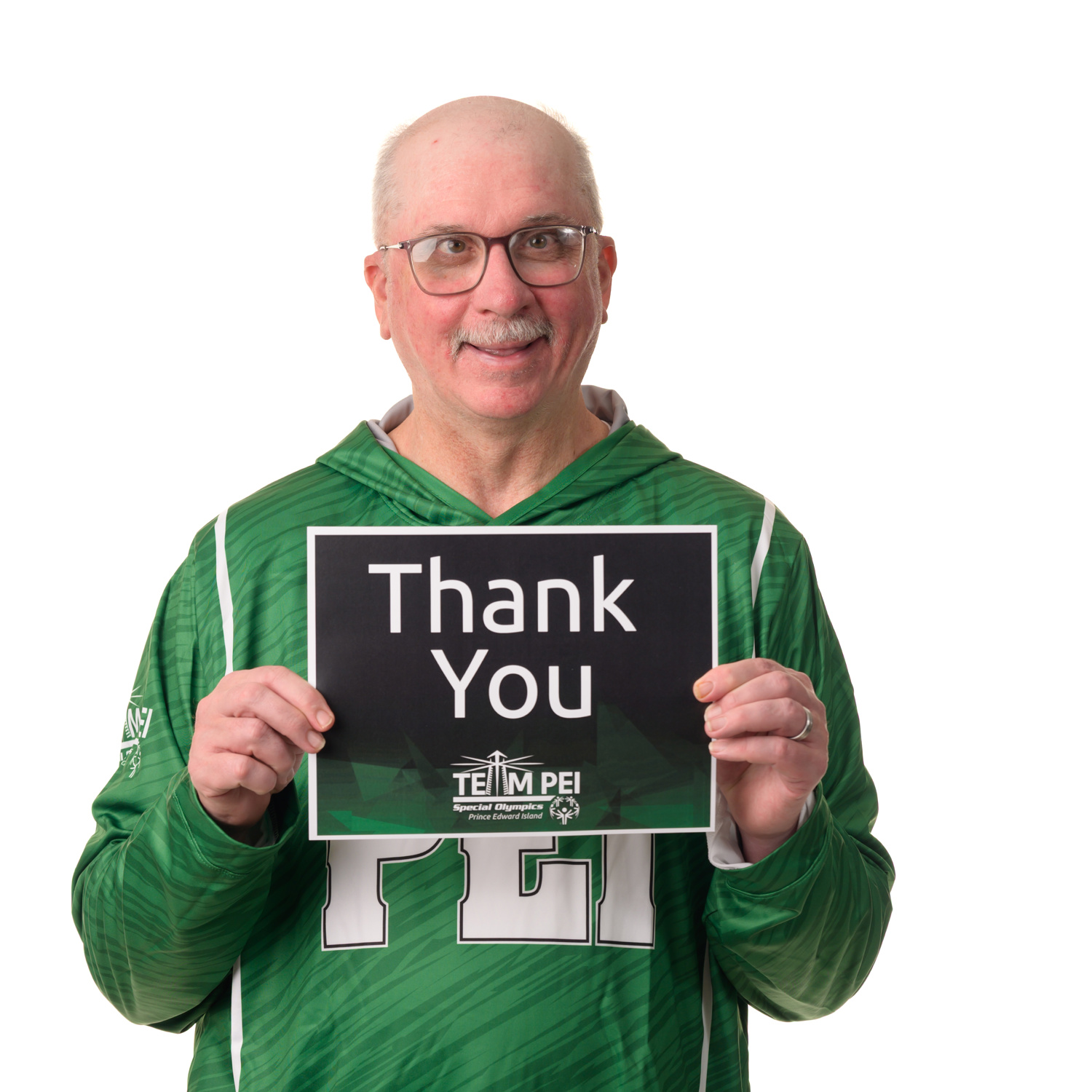 Team PEI 2026 Softball athlete, Tommy MacGuigan, standing with a thank you sign