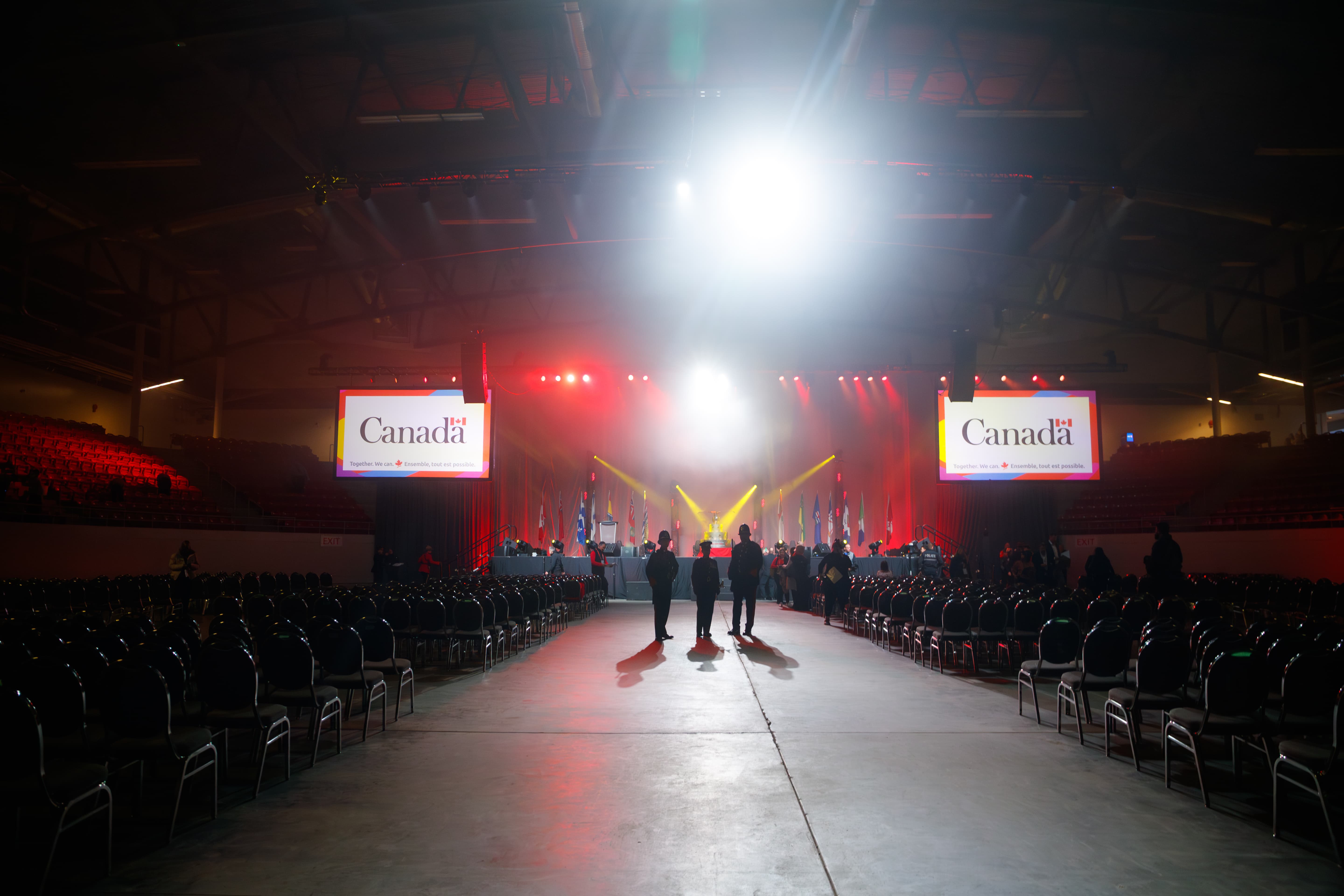 Three people standing in a crowded room with Government of Canada branding Three people standing in a crowded room with Government of Canada branding