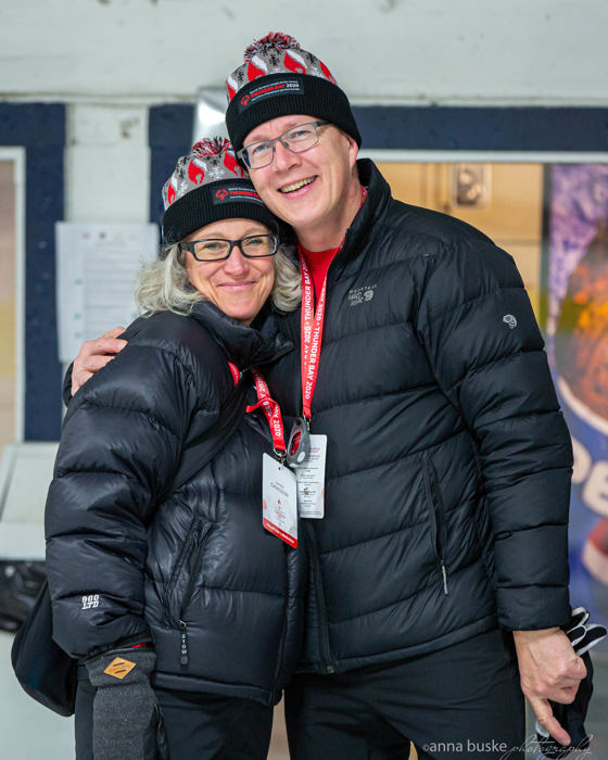 Two people in black winter jackets and Thunder Bay 2020 toques smile at the camera 