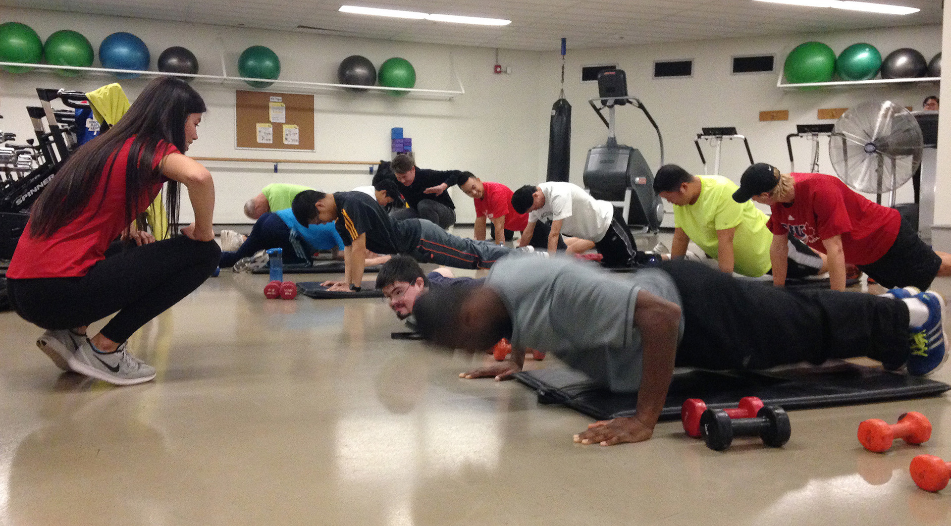 A group of athletes does push-ups in a fitness center.