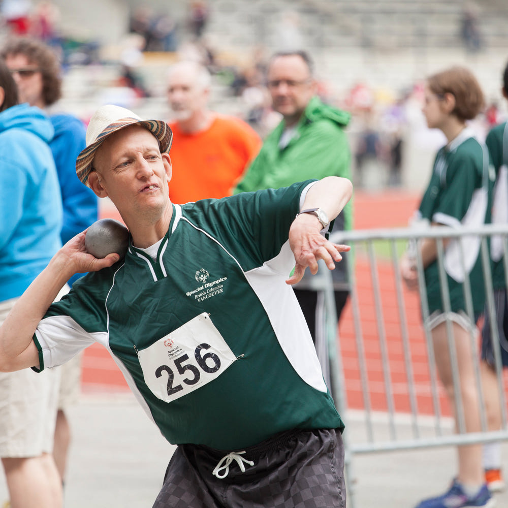 Special Olympics BC athlete positions himself to complete his shot-put throw in competition.