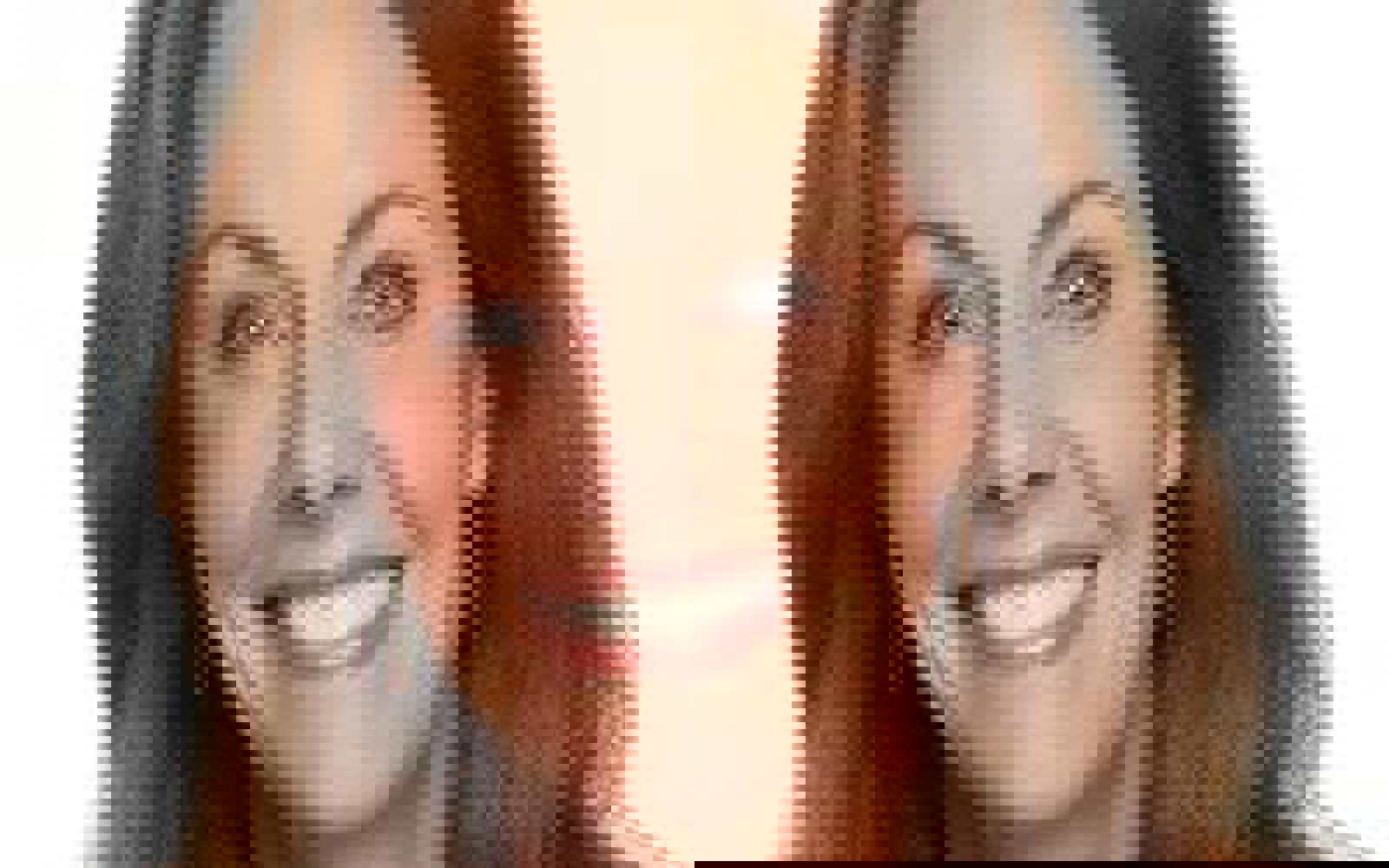 Femme aux cheveux noirs souriant à l'appareil photo.