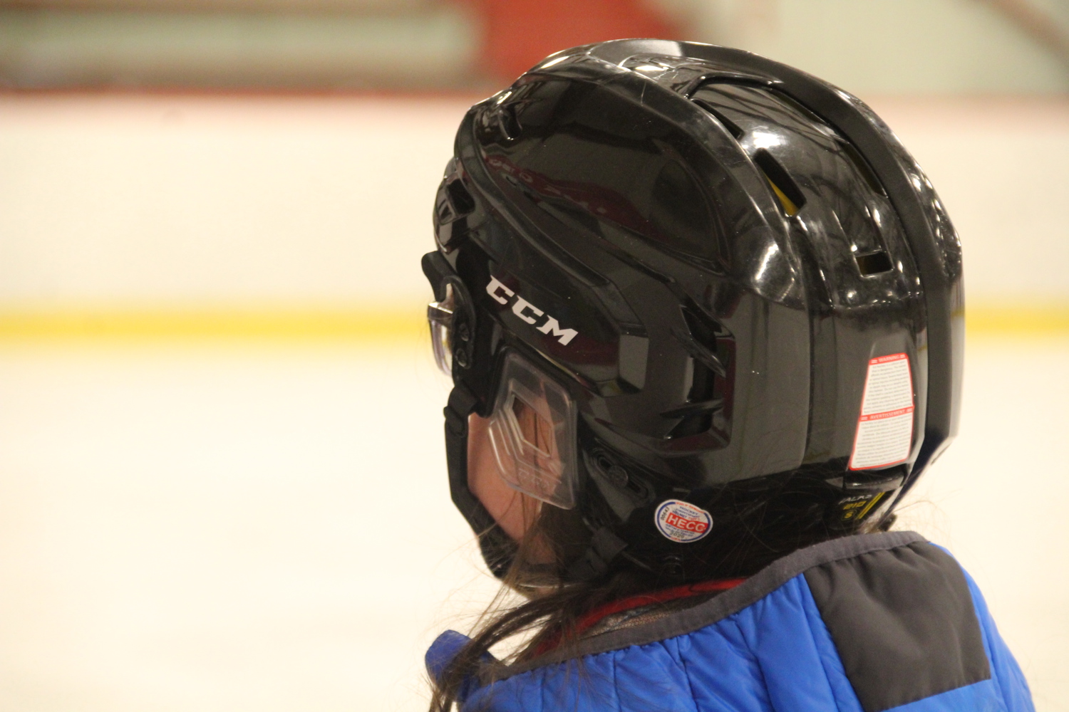 Close up shot of a person wearing a black hockey helmet
