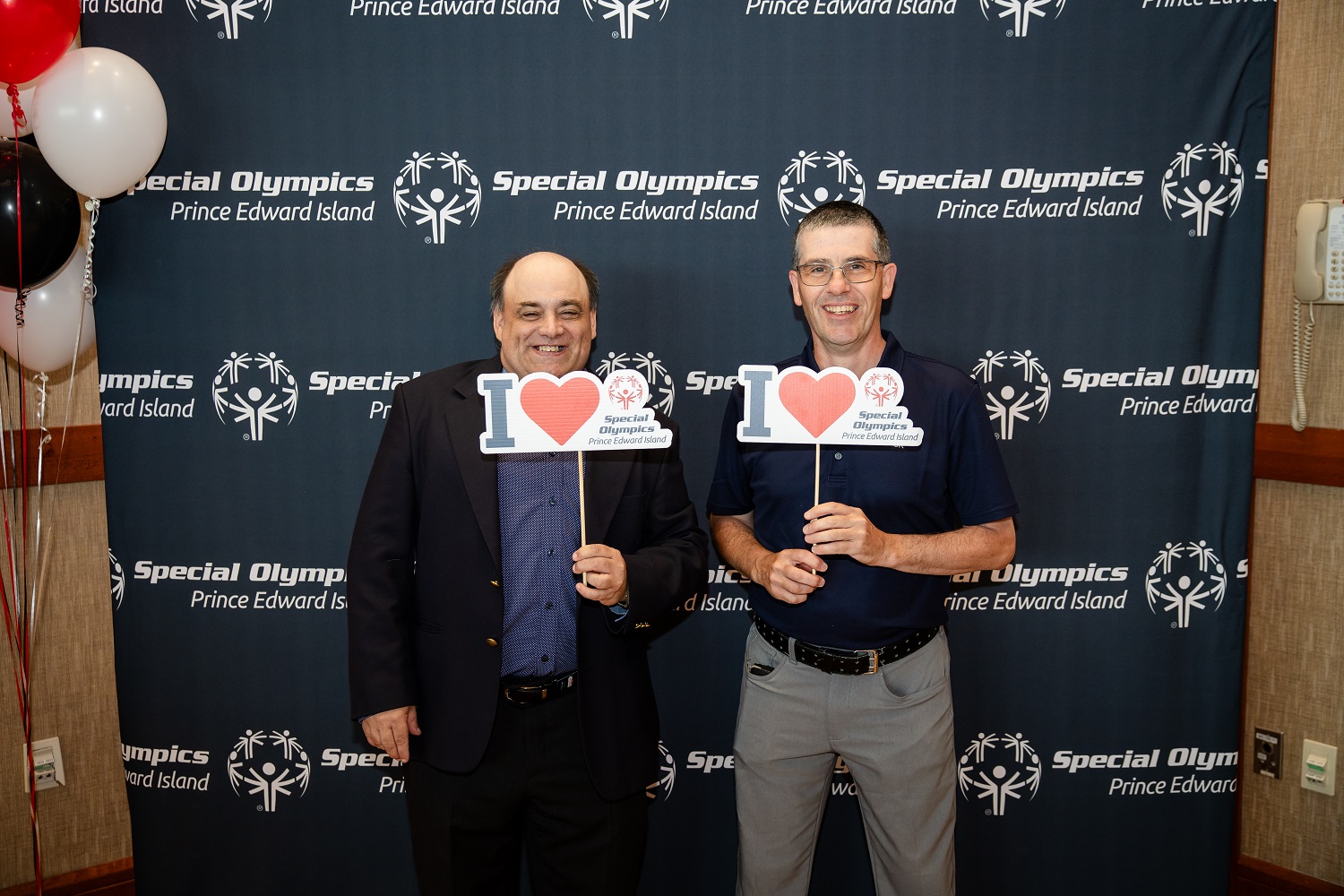 Two Special Olympics athletes standing and holding I Love Special Olympics signs Two Special Olympics athletes standing and holding I Love Special Olympics signs