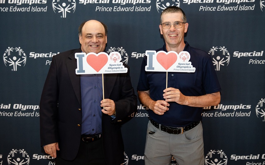 Two Special Olympics athletes standing and holding I Love Special Olympics signs