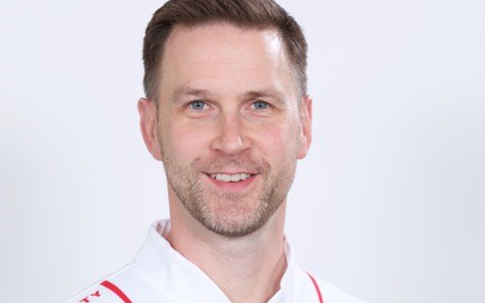 Headshot of a man wearing a jersey with the Tim Hortons logo.