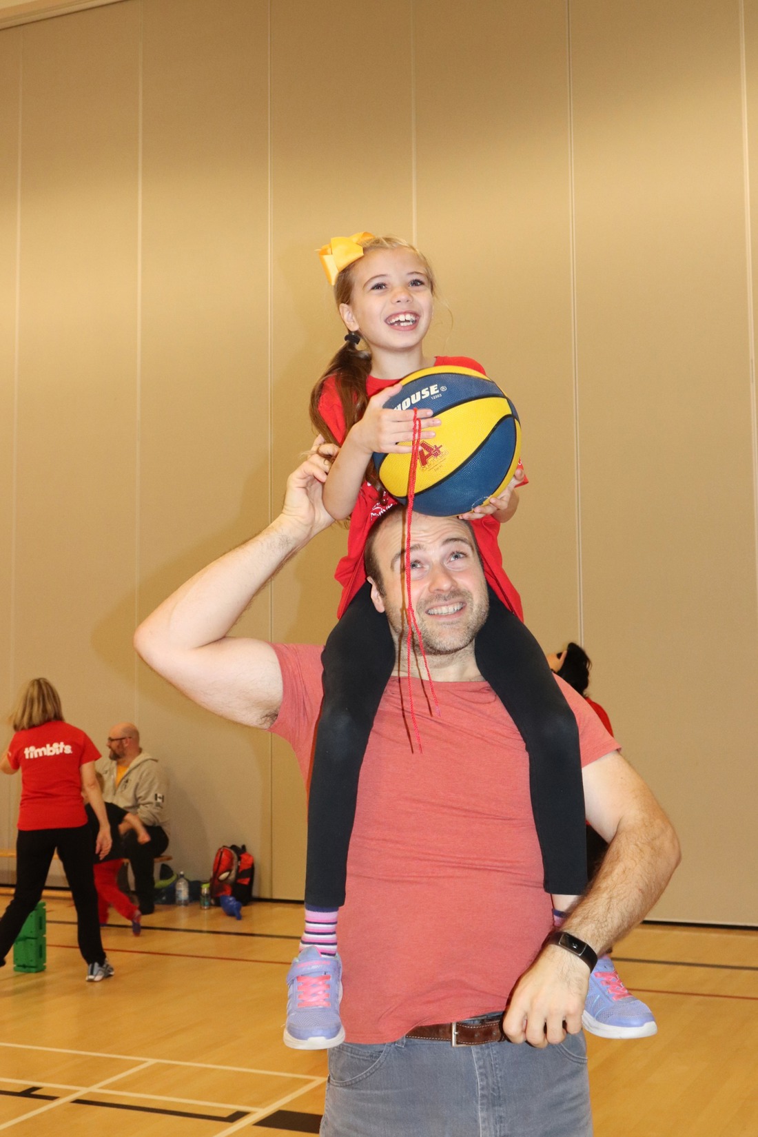 Sophia on guardians shoulders playing basketball.