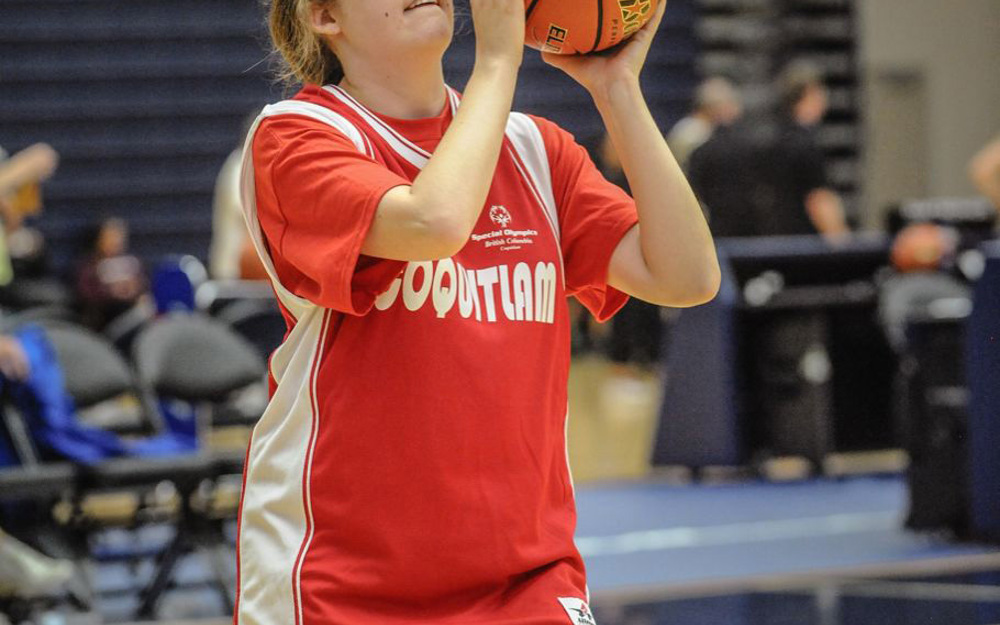 Special Olympics BC basketball athlete with ball poised looks up towards the basket with determination.