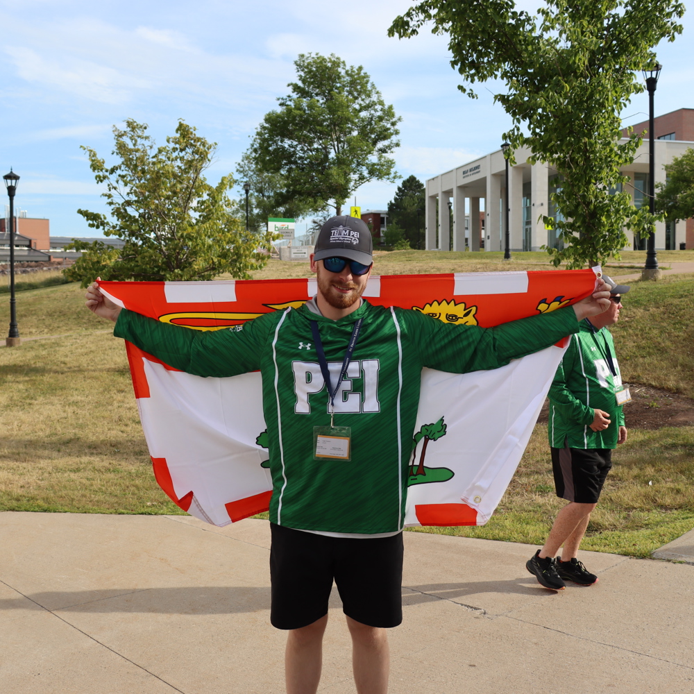 SOPEI Athlete Logan Robbins holding the Team PEI flag at the SONS games July 2025