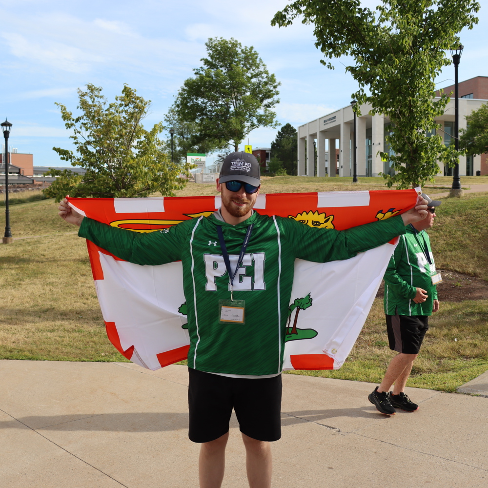 SOPEI Athlete Logan Robbins holding the Team PEI flag at the SONS games July 2025