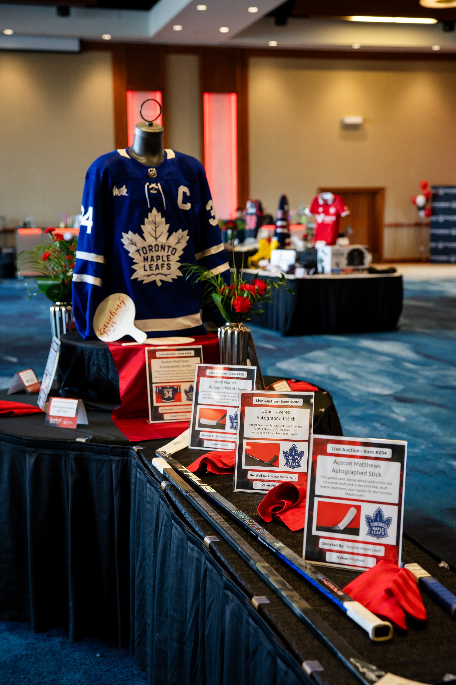 Items on display at a charity auction, including hockey sticks and a jersey Items on display at a charity auction, including hockey sticks and a jersey