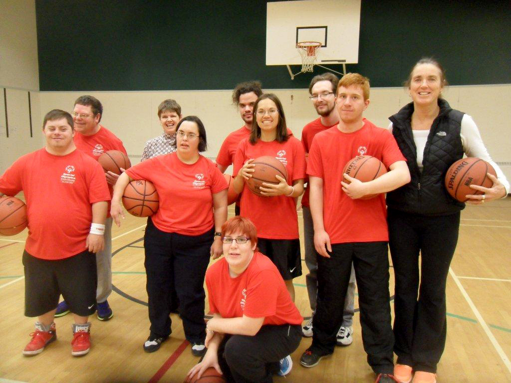 Group photo of basketball athletes with some holding a basketball