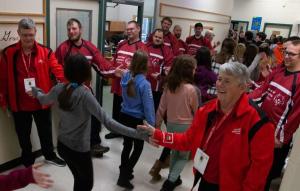 Students form a high-five train with the Special Olympics Ontario floor hockey team on their way into the assembly.
