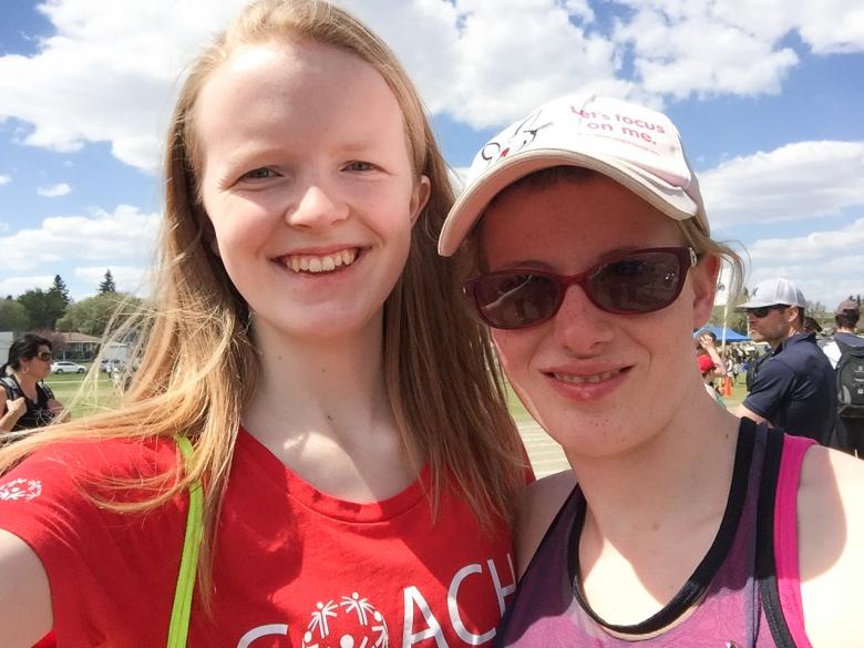 A young volunteer takes a selfie with an athlete.