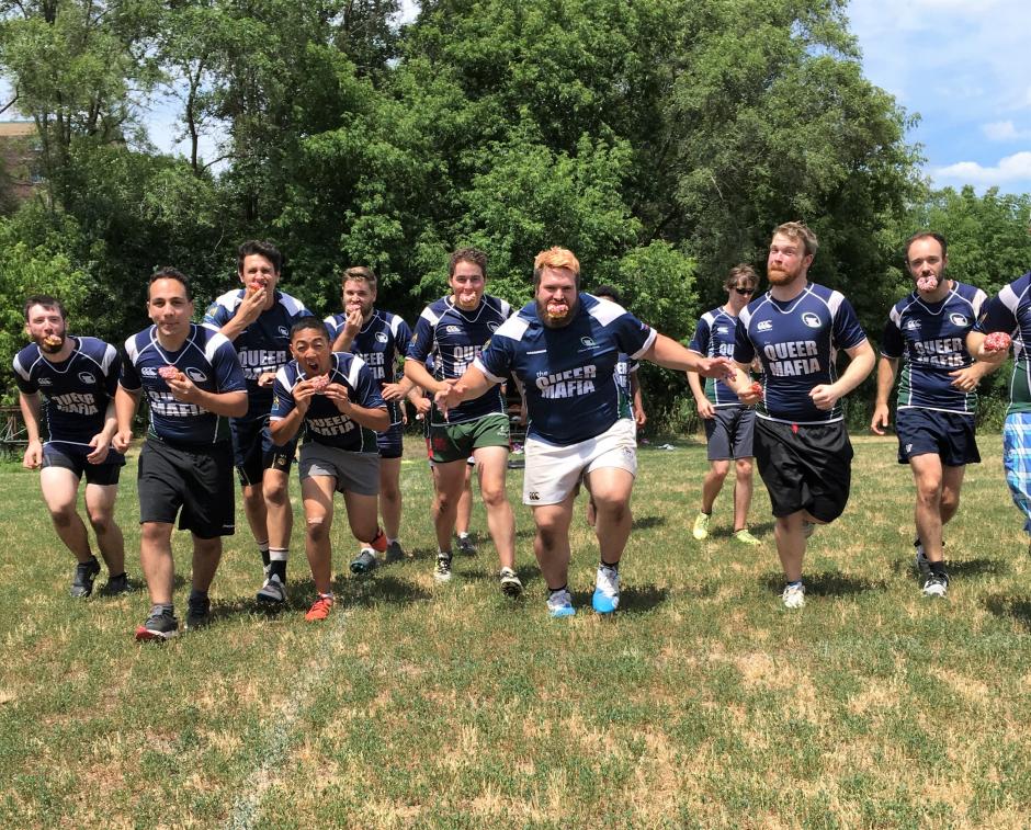 A rugby team runs toward the camera with Special Olympics Donuts in their mouths