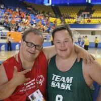 Two Special Olympics basketball players pose for a photo.