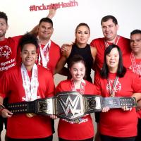 Athletes stand for a photo with WWE star Becky Lynch