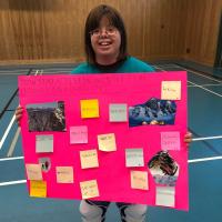 Claire Lemaire holding up poster that describes ways to stay active in the winter