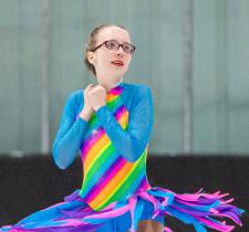 Jordyn Flamma spins on the ice in her rainbow dress.