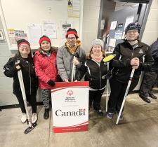 SOBC curling athletes group photo with Government of Canada sponsor sign