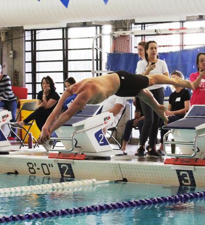 SOBC athlete in mid air diving from the starting block into the pool.