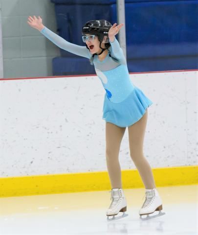 Moriah on the ice with her hands up