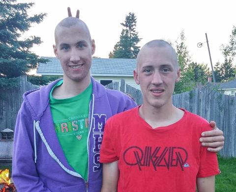 Adam and Brendon stand side by side with their heads shaved, looking into the camera.