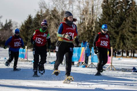 Ariel racing on the snowshoe track with three other athletes behind her