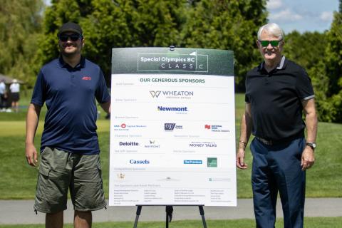 Michael Campbell and SOBC athlete standing on either side of a board with sponsor logos at SOBC Classic event
