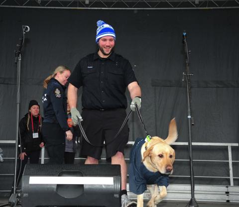 Jeremy holds Briggs his dog on a leash on stage