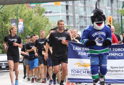 VPD Insp. Joanne Wild, Vancouver Canucks alumnus Chris Higgins, and mascot FIN hit their stride during the Vancouver leg of the Lower Mainland Torch Run. 