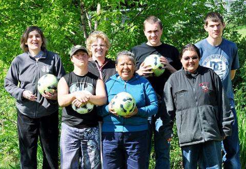 SOBC - Williams Lake soccer players and coaches group photo with half the group each holding a soccer ball