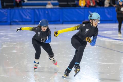 Two SO Team BC 2024 speed skaters racing each other on the ice