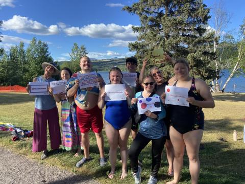 Group photo of SOBC Smithers athletes and coaches showing their #ChooseToInclude signs